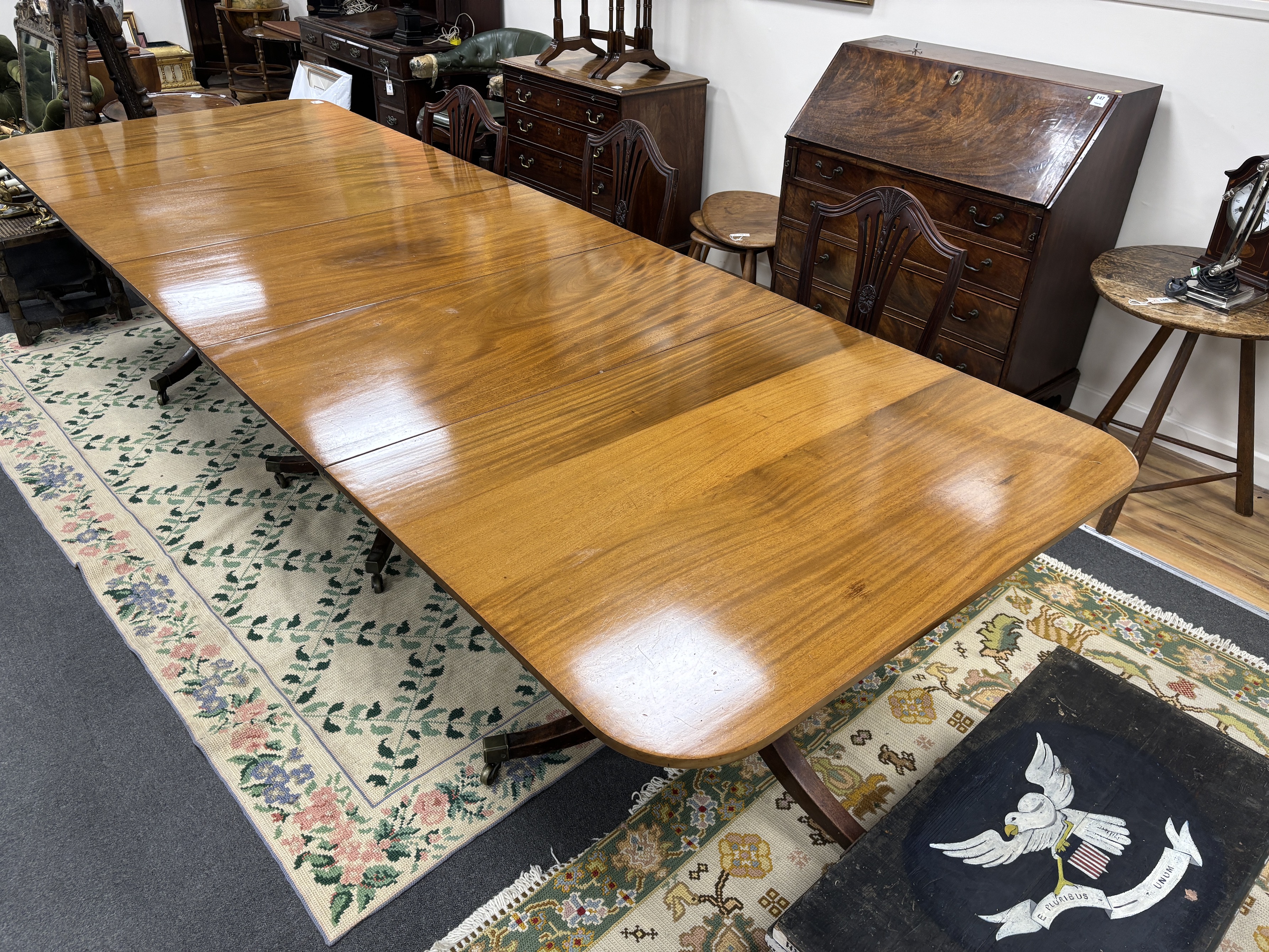 A George III style mahogany triple pillar extending dining table, 346cm extended, two spare leaves, depth 118cm, height 75cm